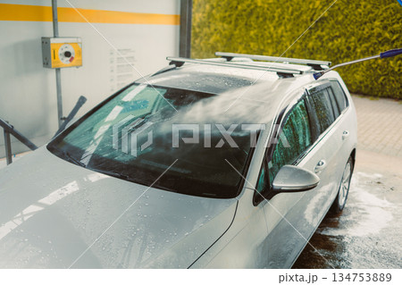 Car Wash A Silver Vehicle is Currently Undergoing a Thorough and Detailed Cleaning Process, Exposed to HighPressure Water Spray, at a StateoftheArt SelfService Car Wash Facility Car Wash A Silver Vehicle is Currently Undergoing a Thorough and Detailed Cleaning Process, Exposed to HighPressure Water Spray, at a StateoftheArt SelfService Car Wash Facility 134753889