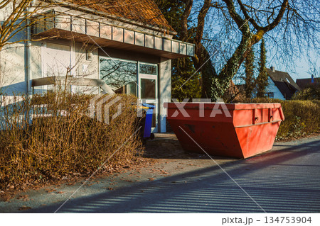 Large metal container for construction waste. Container stands near the house to remove waste after renovation. Removal of construction waste. 134753904