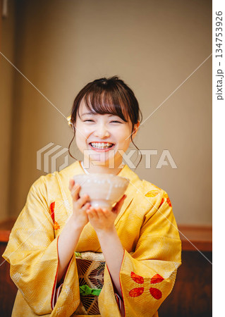 お椀でお茶を飲む若い着物の女性 134753926