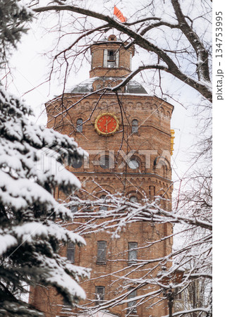 The magnificent snowcovered historic tower stands proudly, surrounded by a stunning winter wonderland, attracting visitors and tourists who wish to explore this beautiful seasonal landscape The magnificent snowcovered historic tower stands proudly, surrounded by a stunning winter wonderland, attracting visitors and tourists who wish to explore this beautiful seasonal landscape 134753995