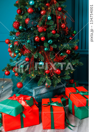 A cheerful Christmas scene features a beautifully decorated tree with glittering lights and colorful presents, creating a joyful atmosphere of celebration and warmth that fills the air A cheerful Christmas scene features a beautifully decorated tree with glittering lights and colorful presents, creating a joyful atmosphere of celebration and warmth that fills the air 134754001