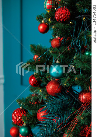 Celebrate the festive spirit this holiday season with vibrant Christmas tree decorations featuring beautiful ornaments in lively red and blue colors, bringing joy and cheer to your home interior 134754003