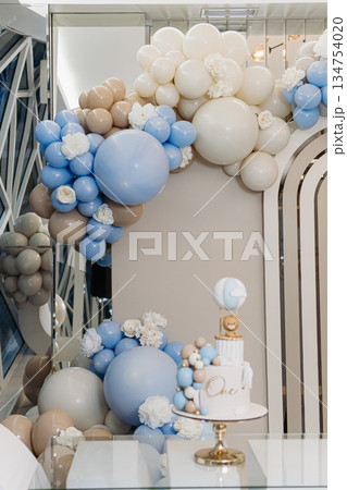 An elegant balloon decoration theme, combined with a beautifully arranged cake display, creates the perfect atmosphere for a memorable first birthday celebration that will be cherished forever An elegant balloon decoration theme, combined with a beautifully arranged cake display, creates the perfect atmosphere for a memorable first birthday celebration that will be cherished forever 134754020