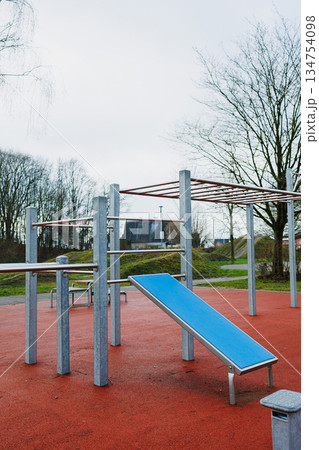A playground with a blue bench is in the middle of the area A playground with a blue bench is in the middle of the area 134754098
