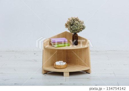 A wooden shelf with a lovely vase of flowers placed elegantly A wooden shelf with a lovely vase of flowers placed elegantly 134754142