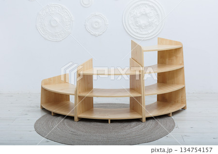 A beautifully curved wooden shelf elegantly sits on a soft rug in a cozy room 134754157