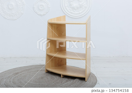 A beautifully crafted wooden shelf is elegantly sitting on a round rug 134754158
