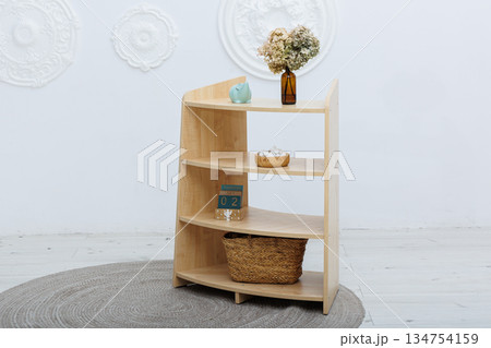 There is a wooden shelf that holds a piggy bank and a basket on it There is a wooden shelf that holds a piggy bank and a basket on it 134754159