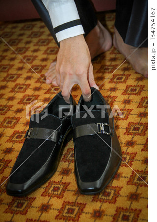 Professional business man tying to put on the dress shoes. A professional, stylish business setting with emphasis on detail and refinement of a fine gentlemen 134754167