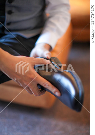 Professional business man tying to put on the dress shoes. A professional, stylish business setting with emphasis on detail and refinement of a fine gentlemen 134754170