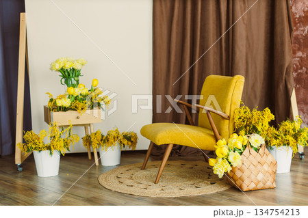 Charming yellow floral decor beautifully arranged with a vintage chair, all set in a bright and inviting studio environment that radiates warmth and style, perfect for any creative space Charming yellow floral decor beautifully arranged with a vintage chair, all set in a bright and inviting studio environment that radiates warmth and style, perfect for any creative space 134754213