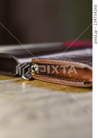 Closeup of elegant leather wallets on rustic wood, highlighting exceptional craftsmanship and quality materials that attract fashion enthusiasts, showcasing style and functionality in one product 134754260