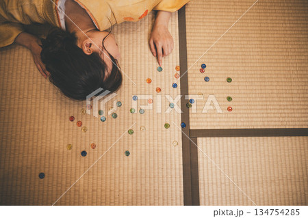 おはじきと黄色い着物を着た若い女性 134754285