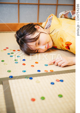 おはじきと黄色い着物を着た若い女性 134754286