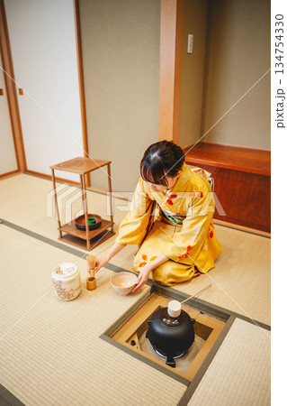 和室で茶道をする若く美しい着物女性 和室で茶道をする若く美しい着物女性 134754330