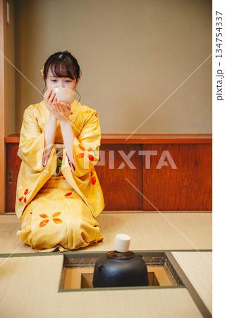 和室で茶道をする若く美しい着物女性 和室で茶道をする若く美しい着物女性 134754337