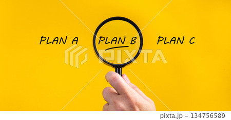 Hand holding magnifying glass focusing on plan b 134756589