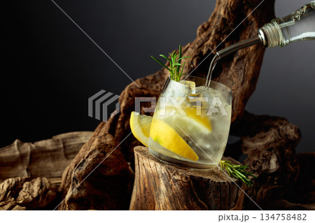 Cocktail gin and tonic with lemon slices and sprig of rosemary. 134758482