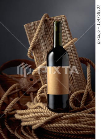 Bottle of port wine with old weathered board and hemp rope. 134758507