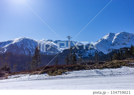 Empty groomed ski slope under a clear blue sky in the mountains. Empty groomed ski slope under a clear blue sky in the mountains. 134759021