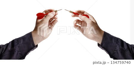 Hands holding darts, tips almost touching, symbolizing conflict or challenge. Sport and Business Concept. Isolated Background. High quality photo Hands holding darts, tips almost touching, symbolizing conflict or challenge. Sport and Business Concept. Isolated Background. High quality photo 134759740