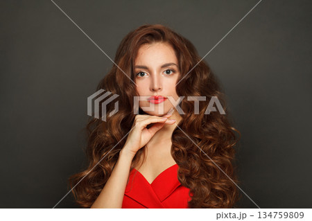 Nice woman with long hair and make-up on black background. Gorgeous woman with curly hairstyle 134759809