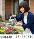 自宅の庭の花壇に水やりをするおかっぱボブの主婦 134760310