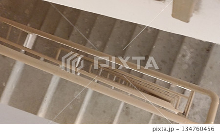 A high-angle view of a staircase with a sleek metal railing, highlighting modern architectural design. Ideal for design illustrations, real estate ads, or architectural publications. A high-angle view of a staircase with a sleek metal railing, highlighting modern architectural design. Ideal for design illustrations, real estate ads, or architectural publications. 134760456
