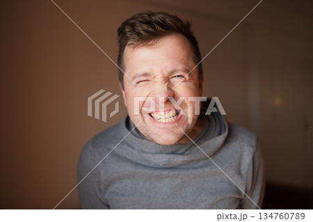 Middle Aged European Man with a Wide Fake Smile, Emotional Portrait Middle Aged European Man with a Wide Fake Smile, Emotional Portrait 134760789
