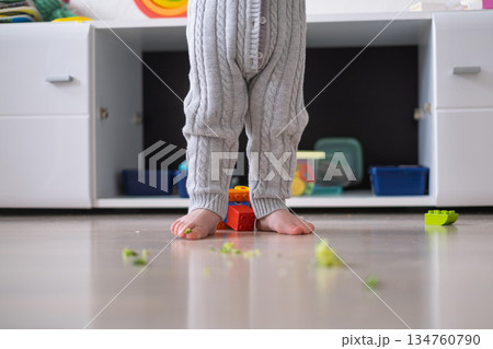 Toddler with Bare Legs Standing on Floor Surrounded by Broccoli Toddler with Bare Legs Standing on Floor Surrounded by Broccoli 134760790