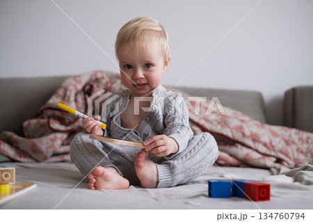 Little Toddler Girl Sitting on Bed Playing with Toys Independently 134760794
