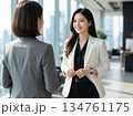 立ち話をしながら仕事の相談にのる女性社員【オフィス】 134761175