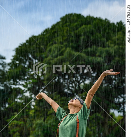 雨の中喜ぶ高齢女性 雨の中喜ぶ高齢女性 134762235