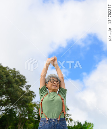 屋外で伸びをする高齢女性 134762257