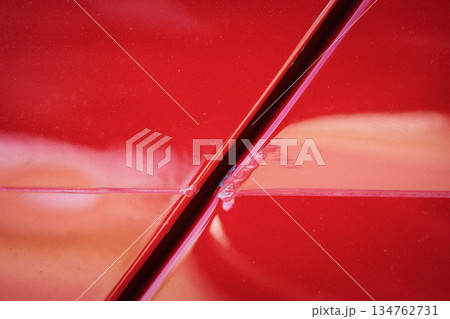 Closeup of red car with paint damage, long scratch Closeup of red car with paint damage, long scratch 134762731