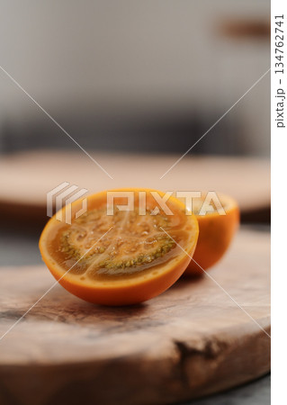 Lulo fruit sliced in halves on olive wood board on kitchen countertop Lulo fruit sliced in halves on olive wood board on kitchen countertop 134762741