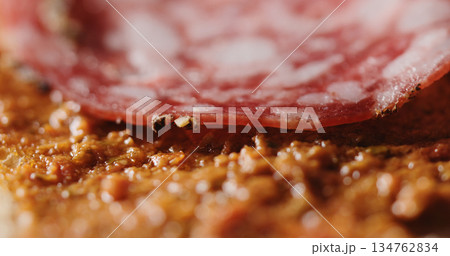 Extreme closeup laying salami slices on ciabatta Extreme closeup laying salami slices on ciabatta 134762834