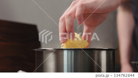 man hand put fettuccine pasta in saucepan with boiling water man hand put fettuccine pasta in saucepan with boiling water 134762844