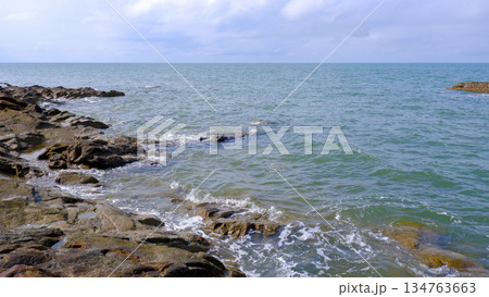 Rocky Coastline Meeting the Calm Blue Sea Rocky Coastline Meeting the Calm Blue Sea 134763663