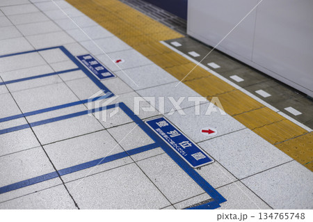 駅ホームの床に描かれた乗車位置案内　整列を促す床表示と点字ブロック 134765748