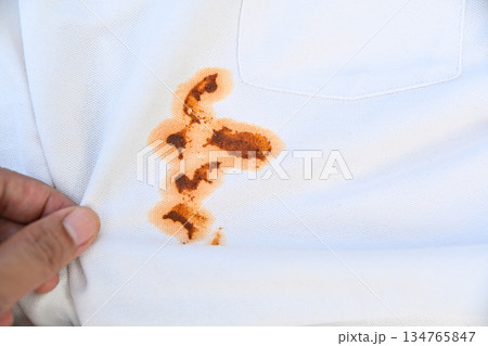hand showing dirty sauce food stain on white shirt from eating in daily life hand showing dirty sauce food stain on white shirt from eating in daily life 134765847