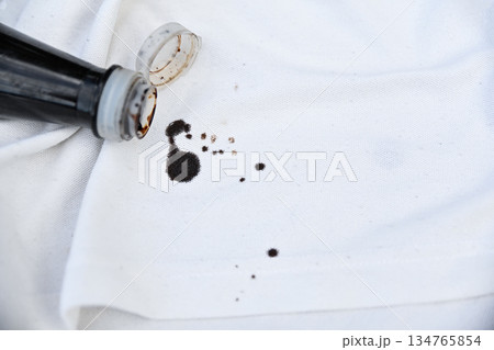 dirty black sauce stain on white shirt in daily life. stain for cleaning concept. dirty black sauce stain on white shirt in daily life. stain for cleaning concept. 134765854