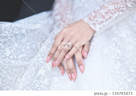 hands of bride wearing wedding ring in ring finger for Valentine's day concept hands of bride wearing wedding ring in ring finger for Valentine's day concept 134765873