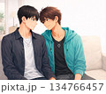 ソファに並んで座る青年カップル　視線を交わすボーイズラブイラスト 134766457