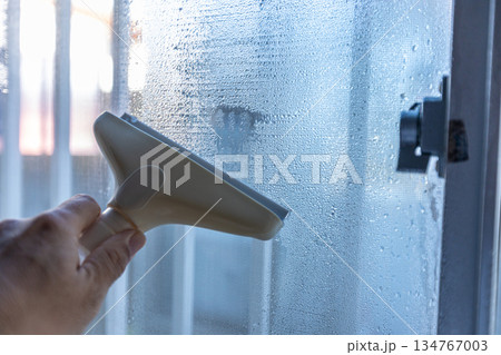 結露取りワイパーで水滴を除去している作業の手元 134767003