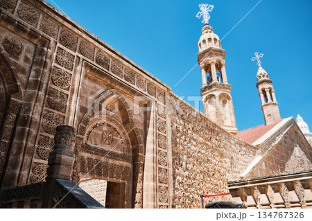 Historic Stone Church with Twin Bell Towers Under Blue Sky 134767326
