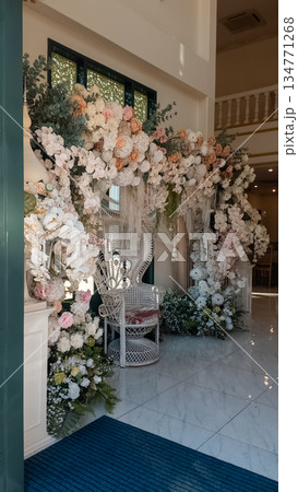 Floral arch decoration with wicker peacock chair wedding backdrop, Luxurious flower arrangement hanging over elegant seating event venue Floral arch decoration with wicker peacock chair wedding backdrop, Luxurious flower arrangement hanging over elegant seating event venue 134771268
