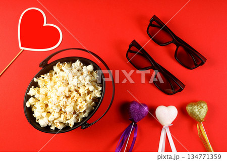Love cinema concept of popcorn. Heart shaped white fluffy popcorn on red background with empty space for text. Valentine days 134771359