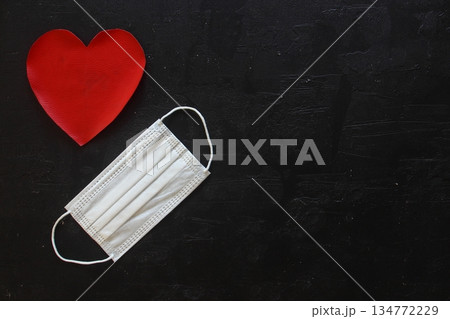 Red plush heart with face mask on stone background. Top view, copy space. Valentines day concept. 134772229