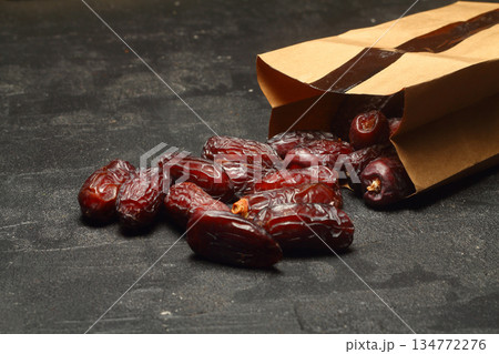 Dried dates on a wooden table in silver dishes close-up. Composition of dried dates in ramadan dish 134772276